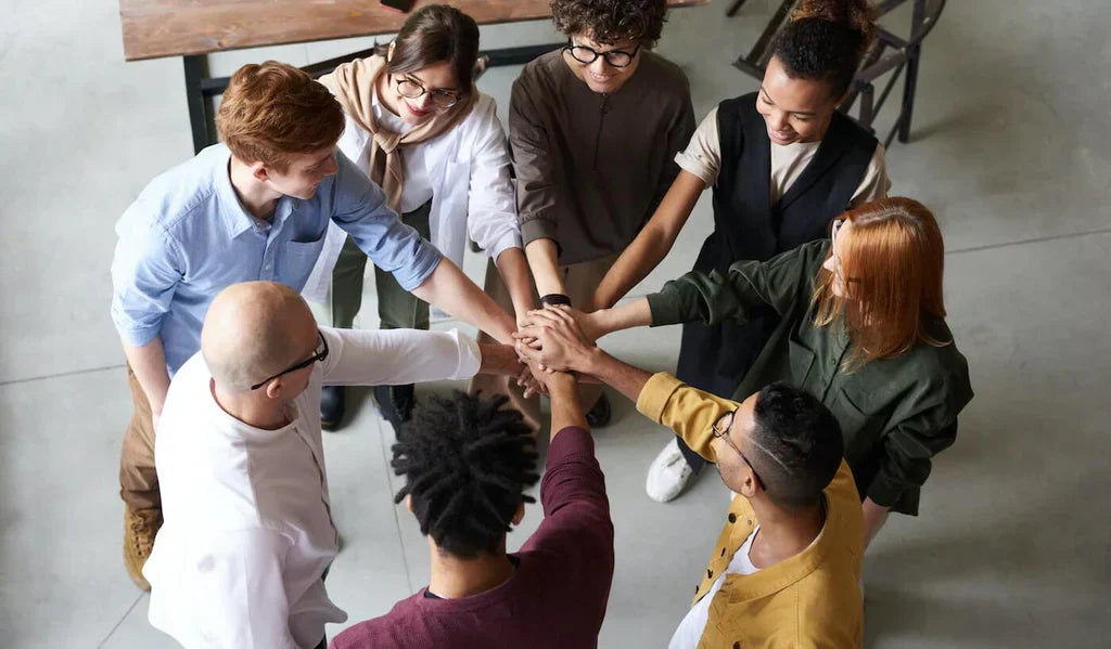 A group of employees in a circle doing a group huddle