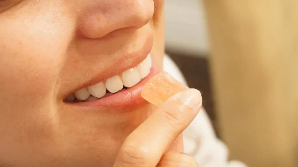 A closeup of a woman's mouth while eating a THC edible