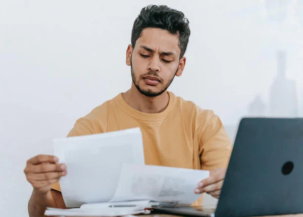 Man sitting by his laptop reading about CLIA Waived Drug Tests